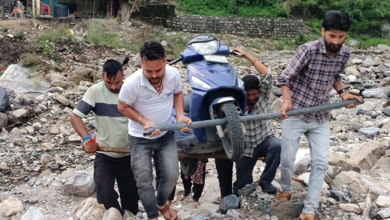 भारी बारिश के बाद टिहरी जिले  के सीतापुर में टूटी सड़क, स्कूटी कंधे पर उठाकर पार कर रहे लोग
